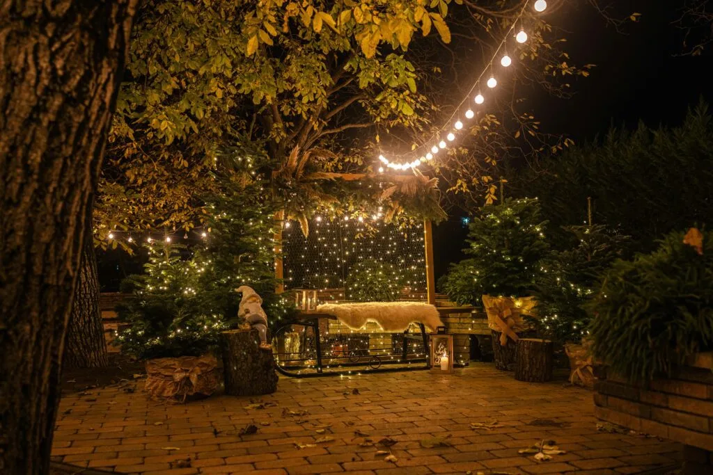 DIY wedding lighting ideas Smart Makeshift Wedding Ideas -A cozy outdoor patio adorned with string lights and decorations, creating a warm festive ambiance at night.